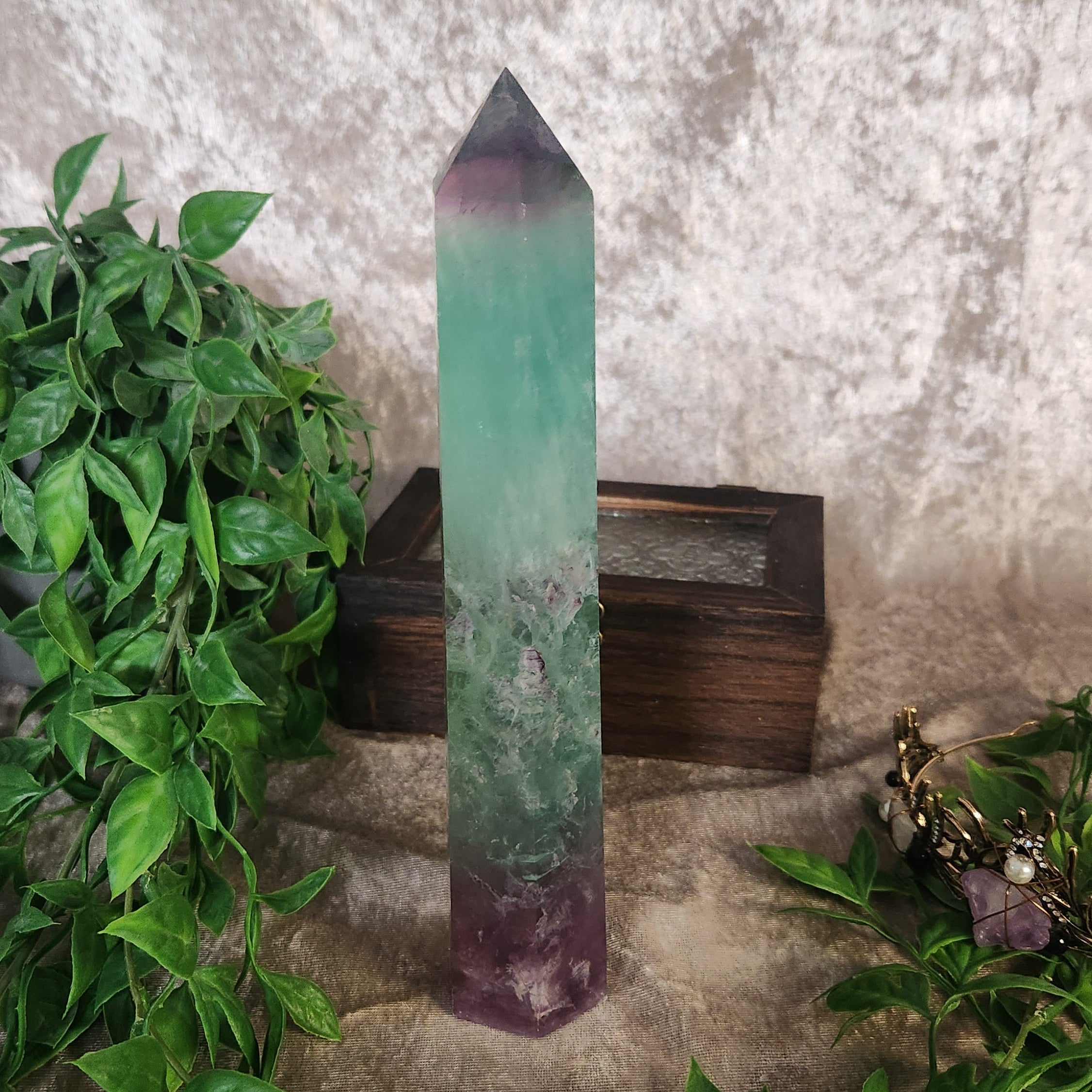 Polished rainbow fluorite tower showing translucent green and violet layers