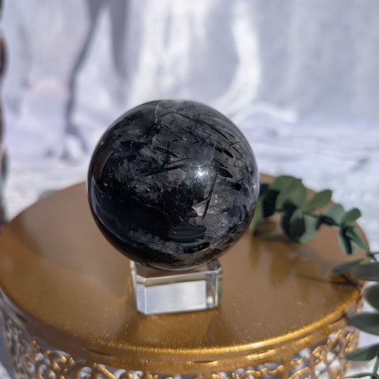 Polished tourmaline in quartz sphere with dark internal formations