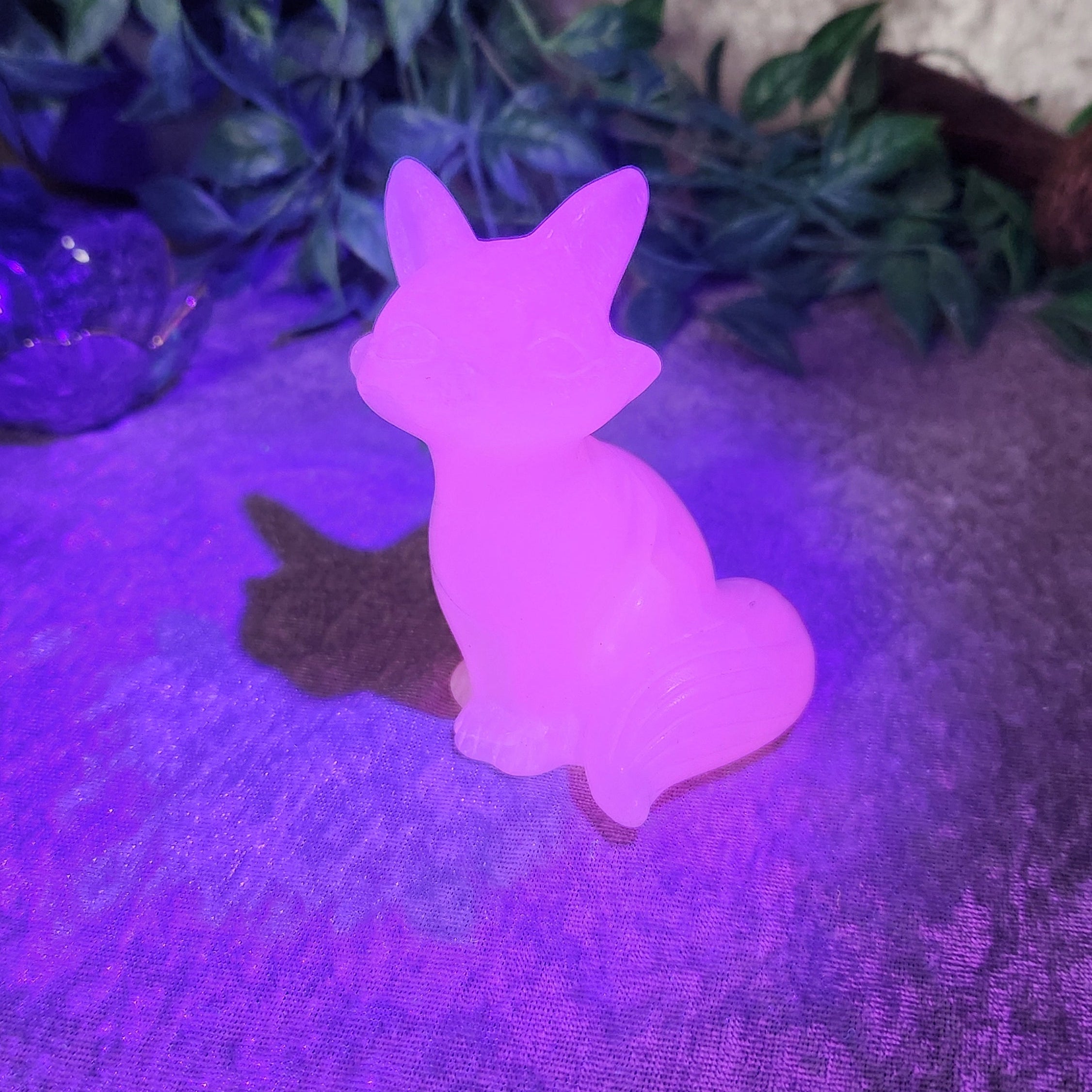 UV Reactive Hand carved calcite fox figurine showing soft translucence and flowing tail detail